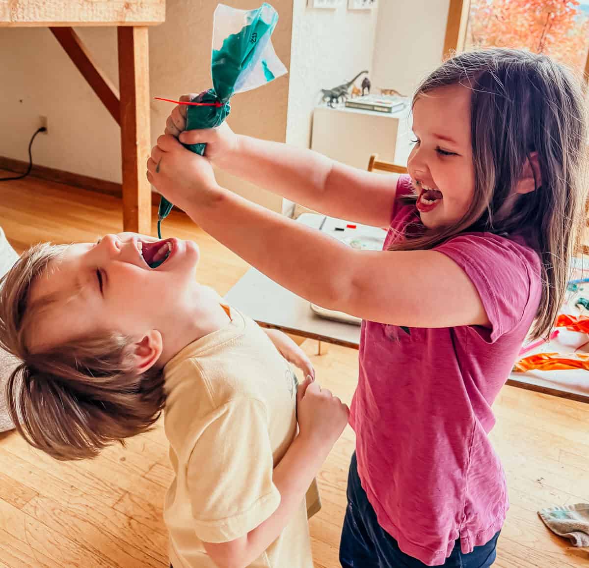 Katalina and John are having too much fun squeezing piping bags of royal icing into each others' mouths