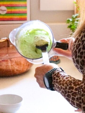 transferring feta sauce to a mise en place bowl to serve