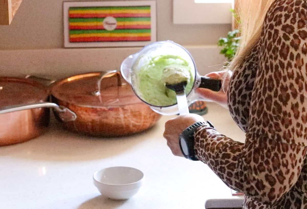 transferring feta sauce to a mise en place bowl to serve