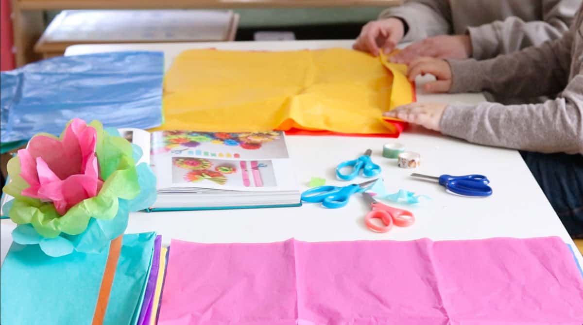 Noah is accordion folding his tissue paper