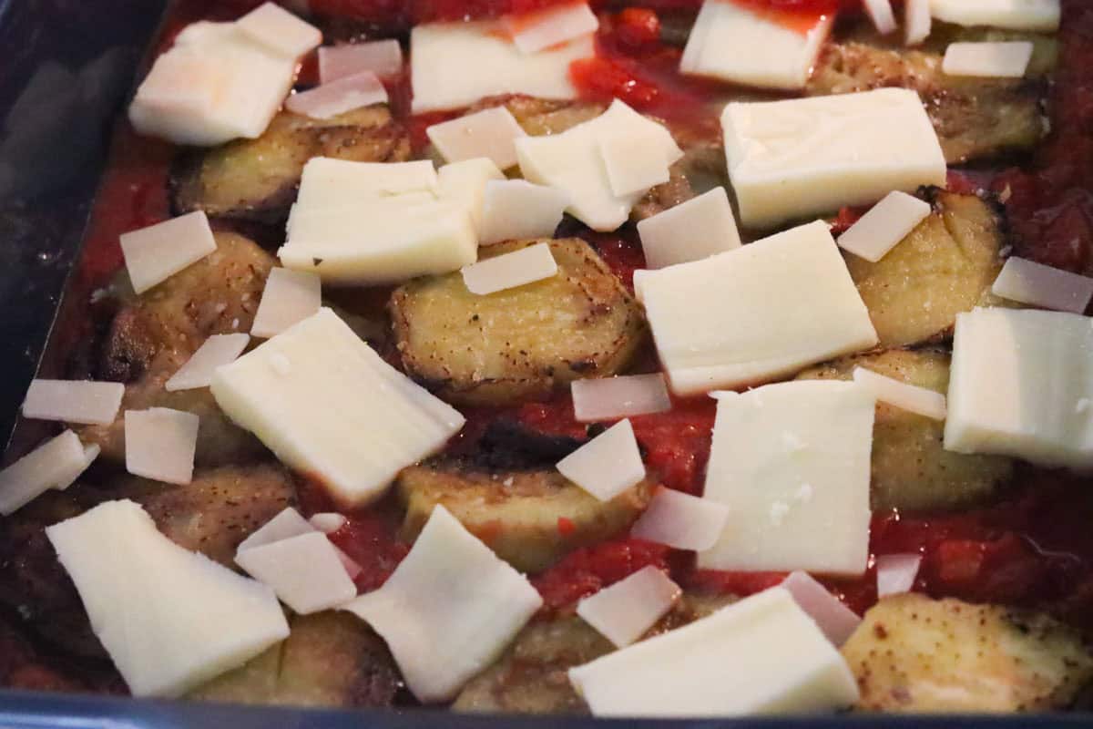 mozzarella and Parmesan cheese on top of eggplant slices and sauce