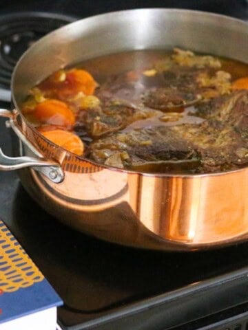 gullah geechee pot roast in a copper rondeau on the stove
