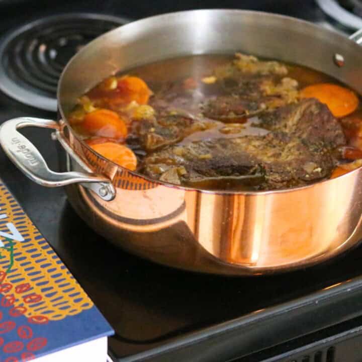 gullah geechee pot roast in a copper rondeau on the stove