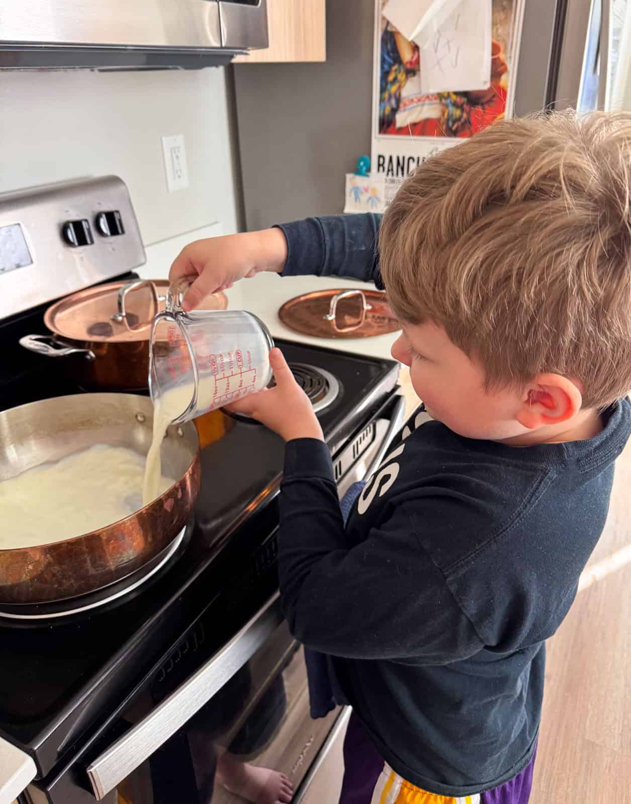 noah is pouring eggnog ingredients into a saucier