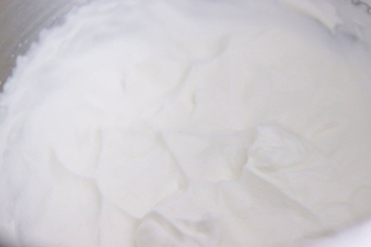 homemade whipped cream with soft peaks in a mixing bowl