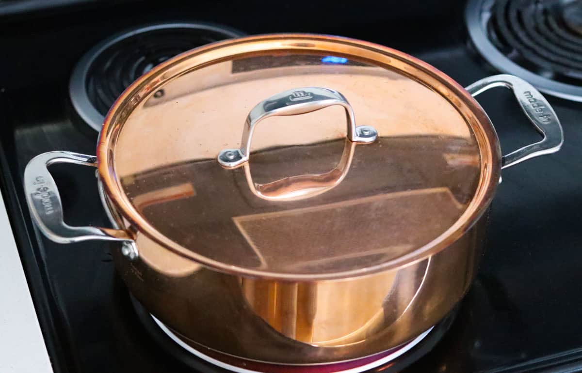 made in copper rondeau with lid on the stove