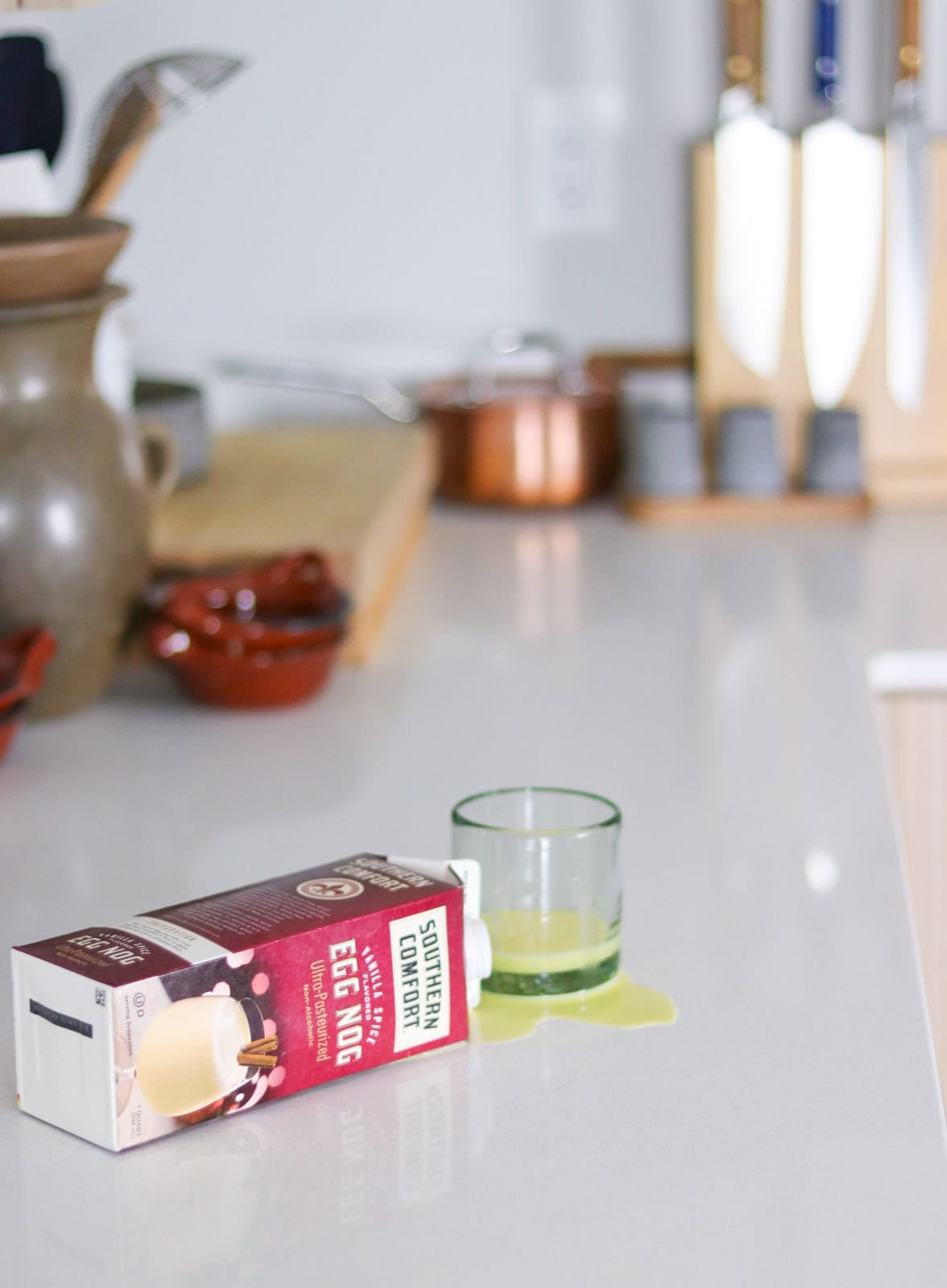 tipped over southern comfort egg nog beside an empty glass