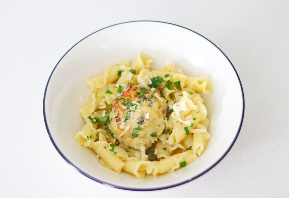chicken piccata meatball over a bed of campanelle, topped with parsley and Parmigiano-Reggiano