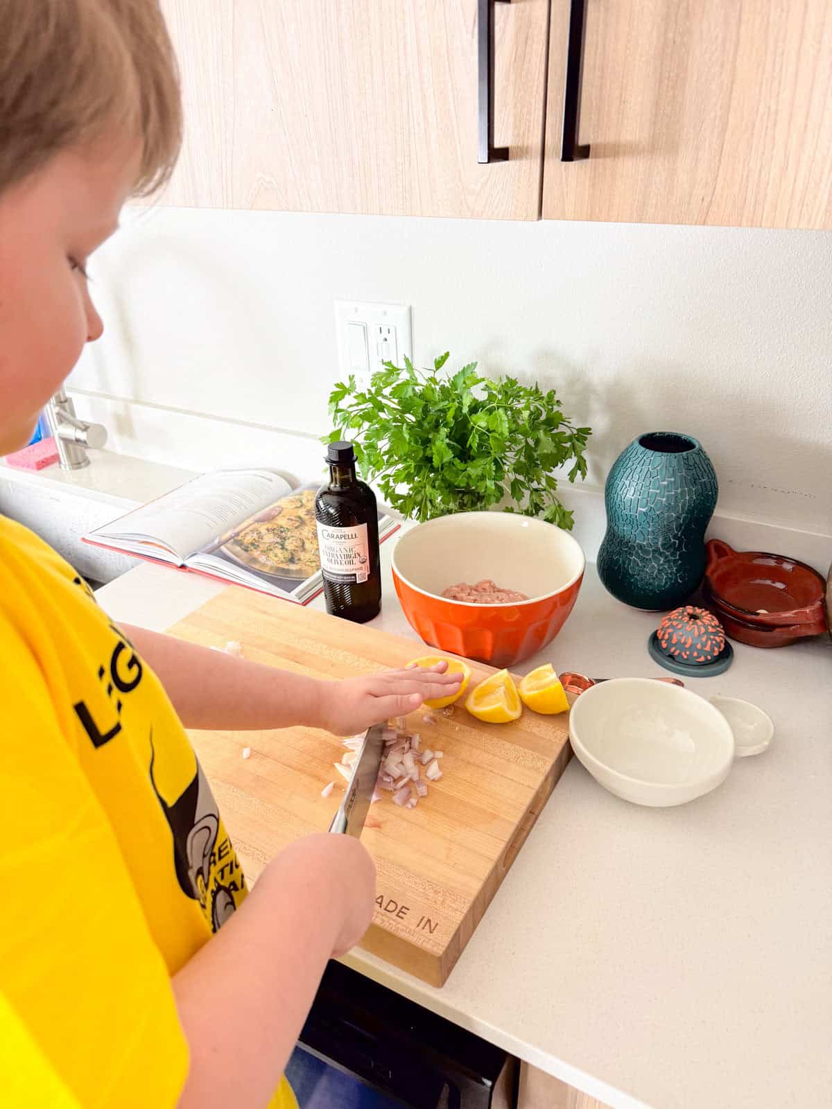 Noah is slicing shallots having learned how to dice with minimal cuts