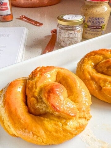 soft pretzels on a baking slab, Giadzy spicy seasoned salt, and Grey Poupon country dijon mustard