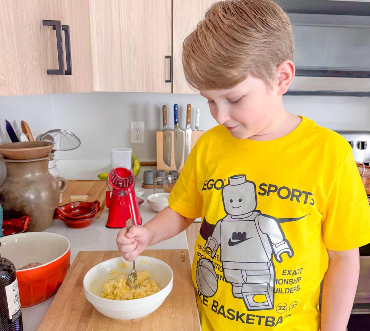 Noah is stirring ingredients for chicken piccata meatballs