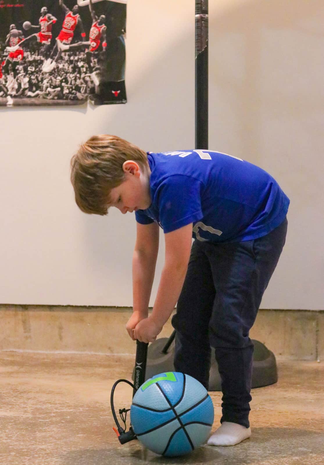Noah is inflating a Jordan Playground Luka Dončić basketball with a manual pump