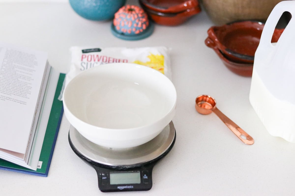 bowl on a kitchen scale, measuring spoon, and milk for making homemade icing