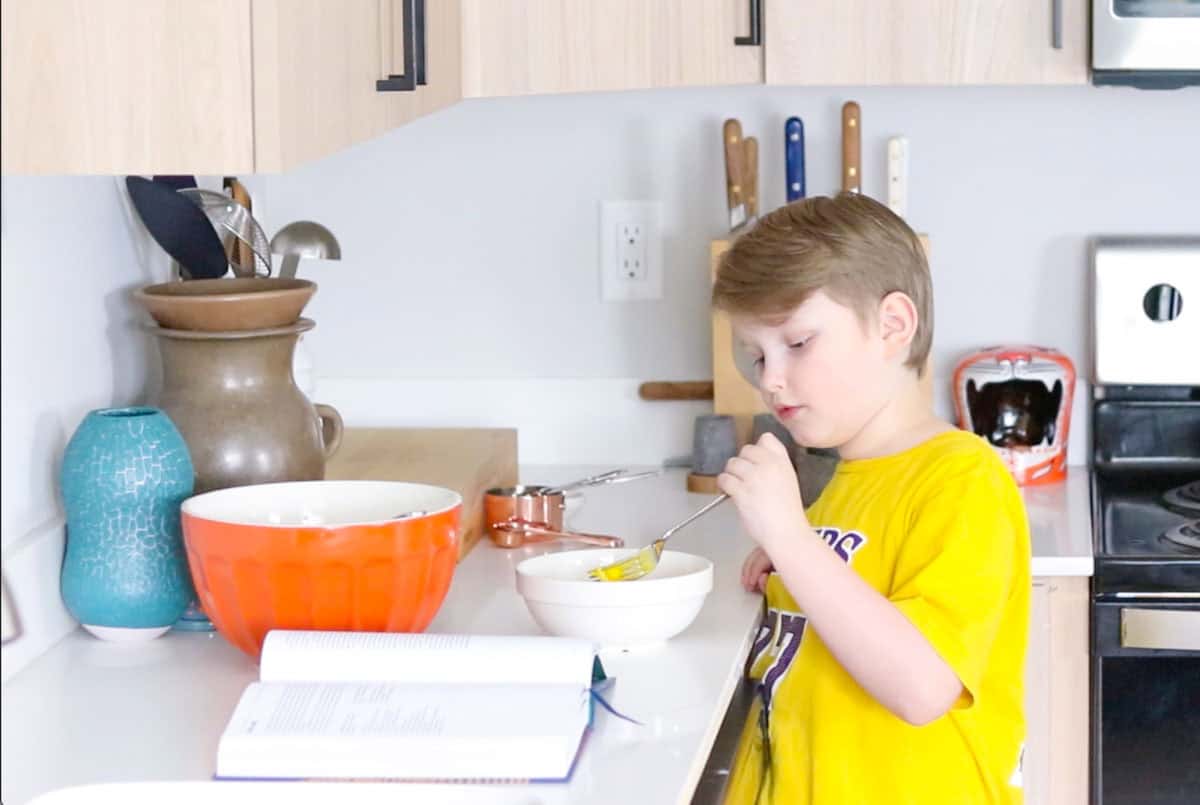 Noah is playing with beaten egg yolks in a bowl