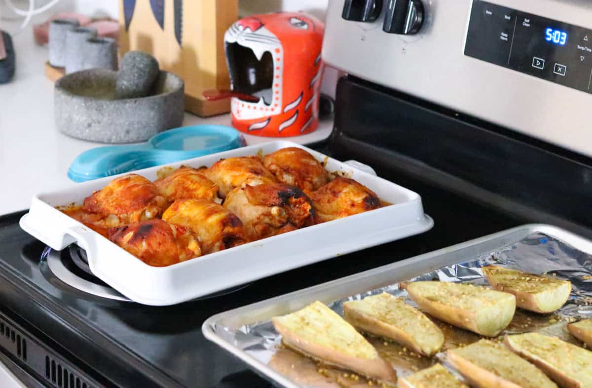 gochujang chicken on a baking slab beside sesame sweet potatoes
