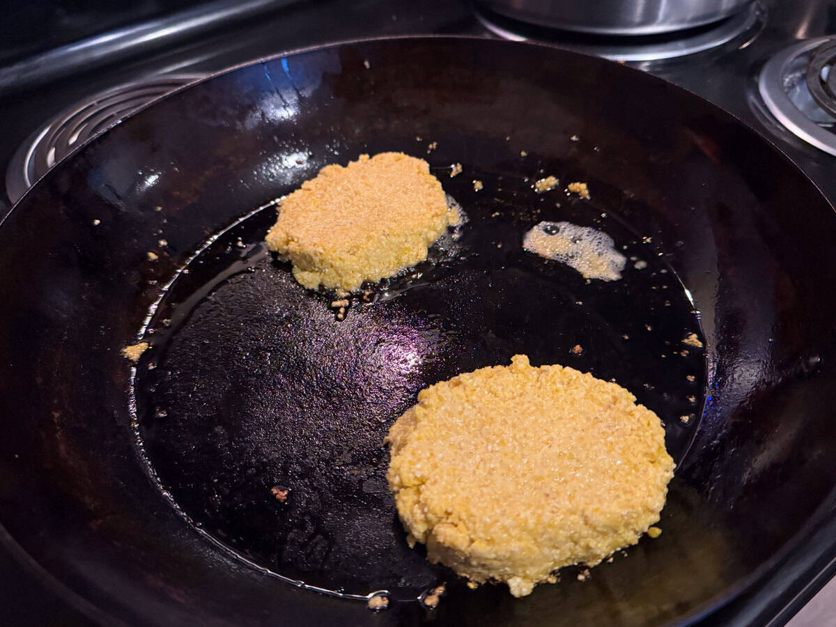 hoecakes cooking in a carbon steel frying pan
