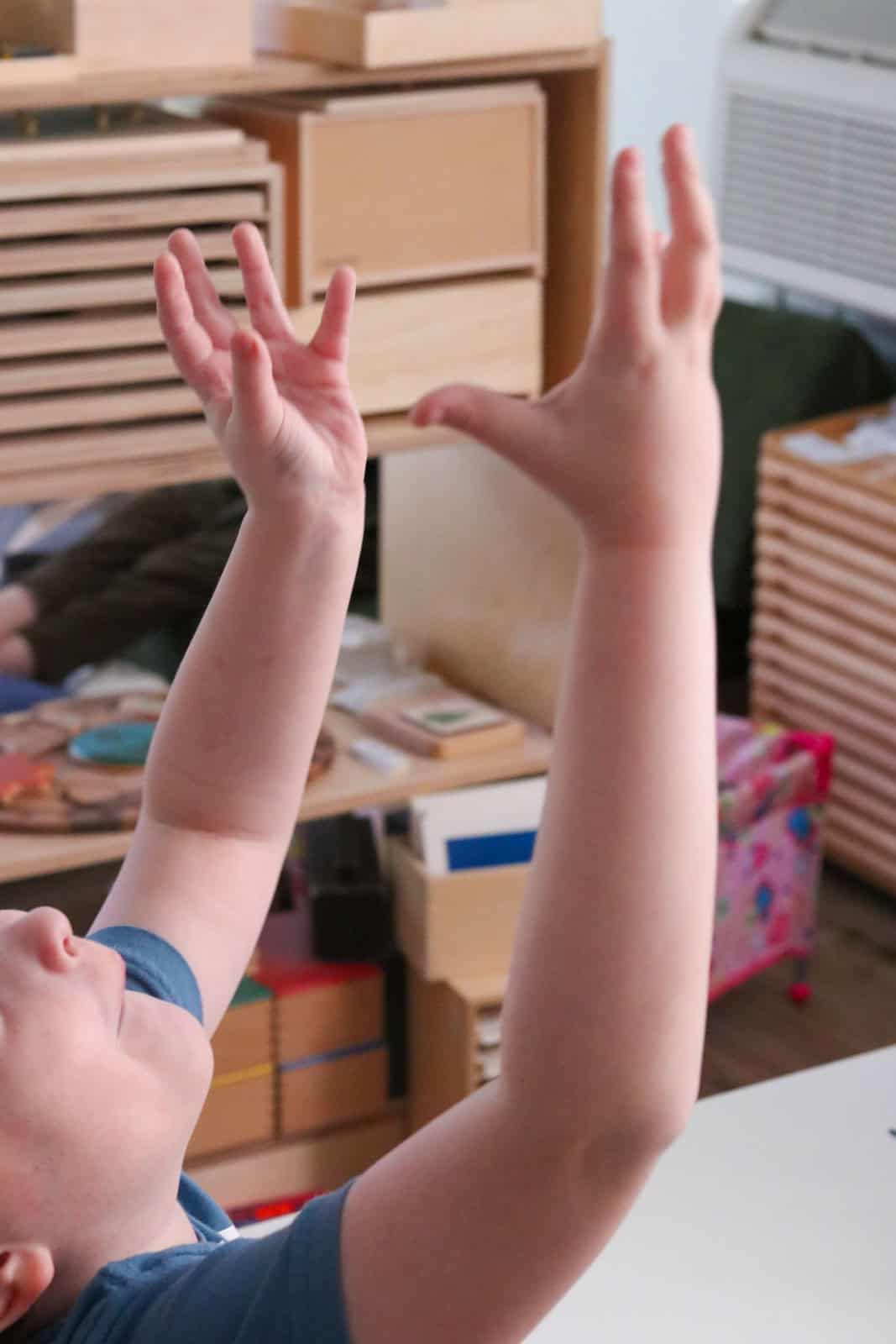 Noah is throwing his hands up in the air because I keep asking him to tie his shoes