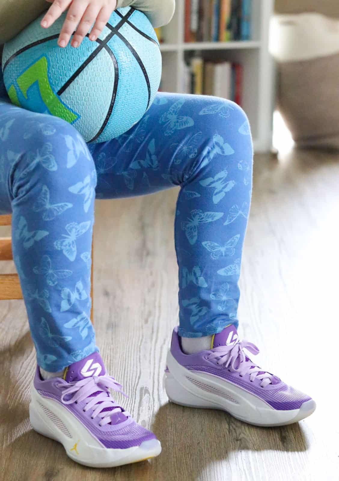Kaia is holding a Jordan Luka Dončić basketball and wearing Jordan Luka 5 Luka Lifestyle sneakers