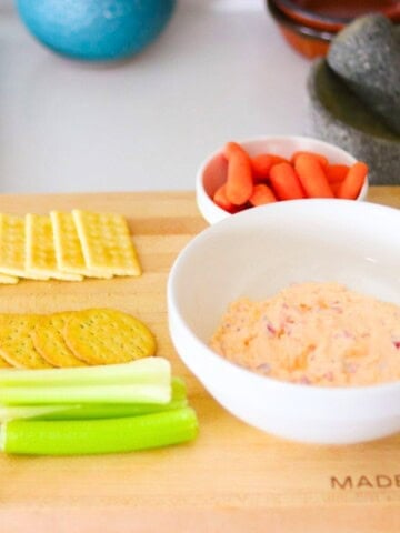 pimento cheese, crackers, and vegetables on a butcher block