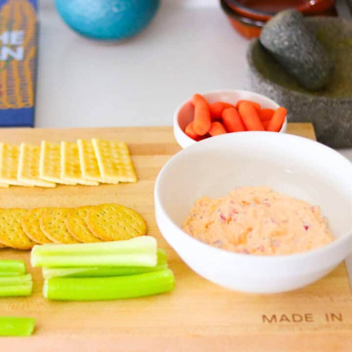 pimento cheese, crackers, and vegetables on a butcher block