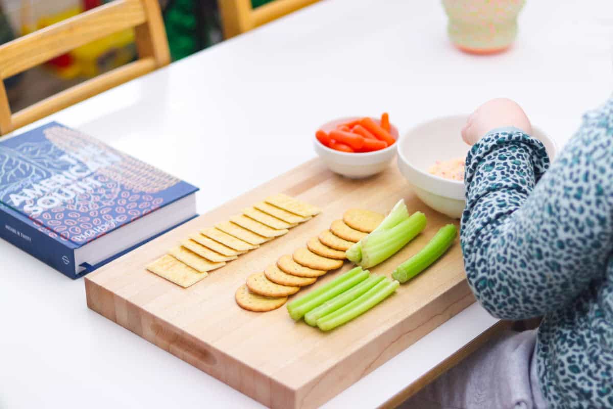 Kaia is tasting the pimento cheese with crackers or veggies