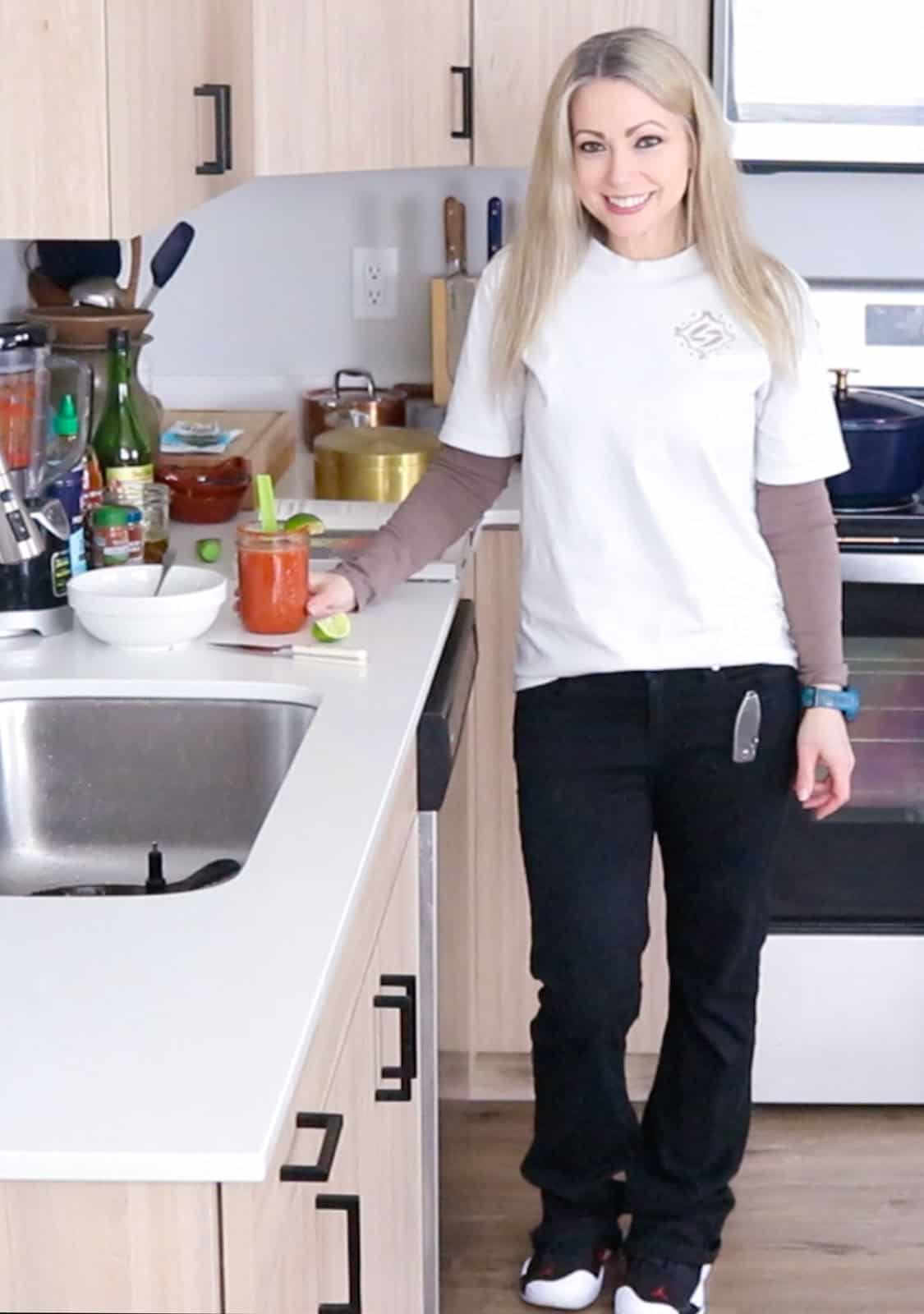 Kristin is standing in the kitchen and clutching a sake bloody mary