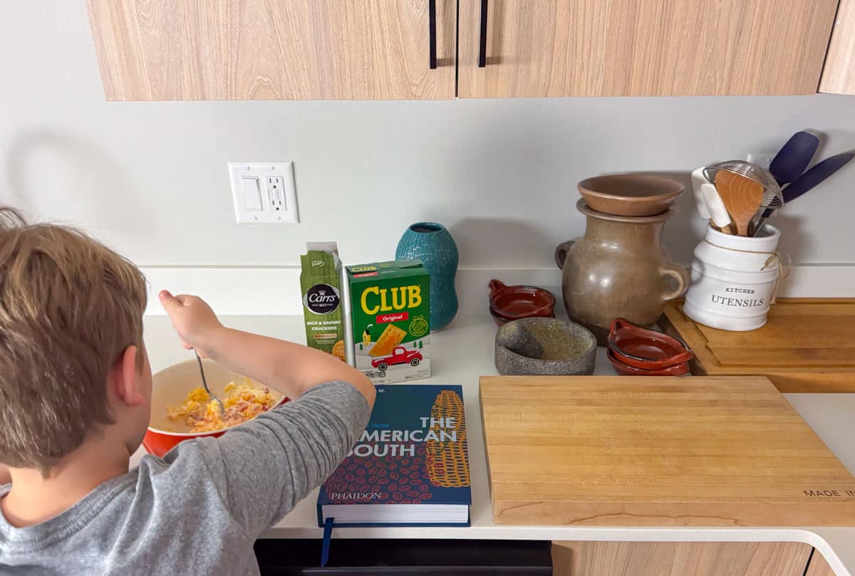 Noah is stirring pimento cheese ingredients in a bowl