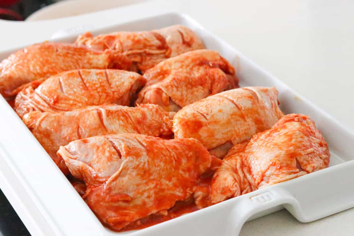 raw chicken thighs on a baking slab