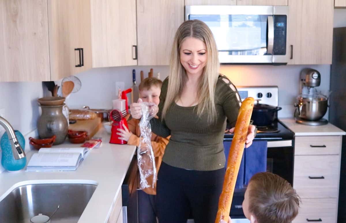 Kristin is handing John a baguette