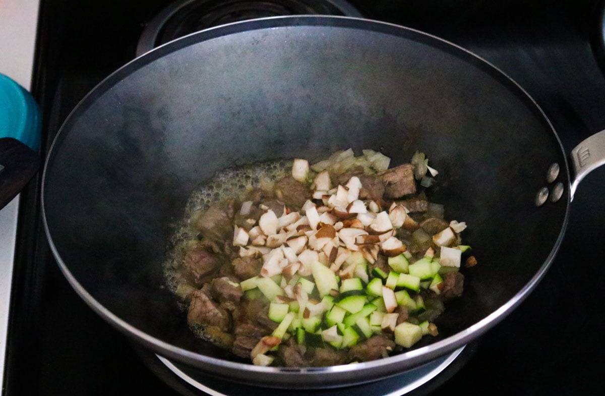 bibimbap ingredients frying in a wok