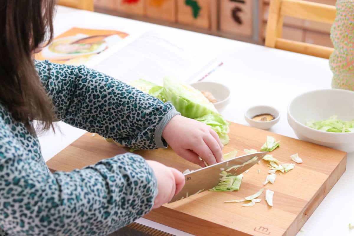 Kaia is chopping cabbage