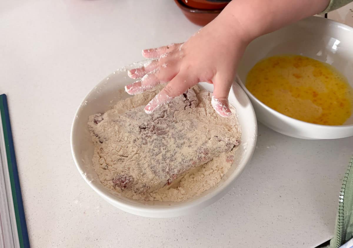dredging cube steak in a flour mixture