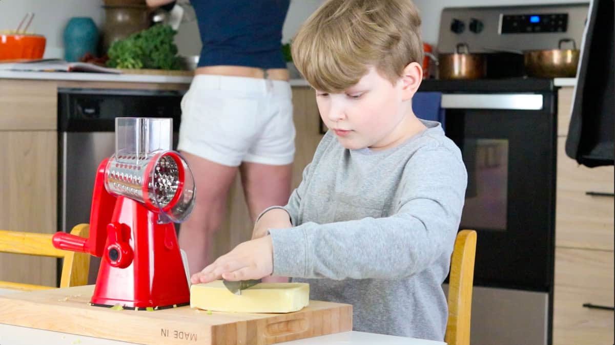 Noah is cutting mozzarella cheese