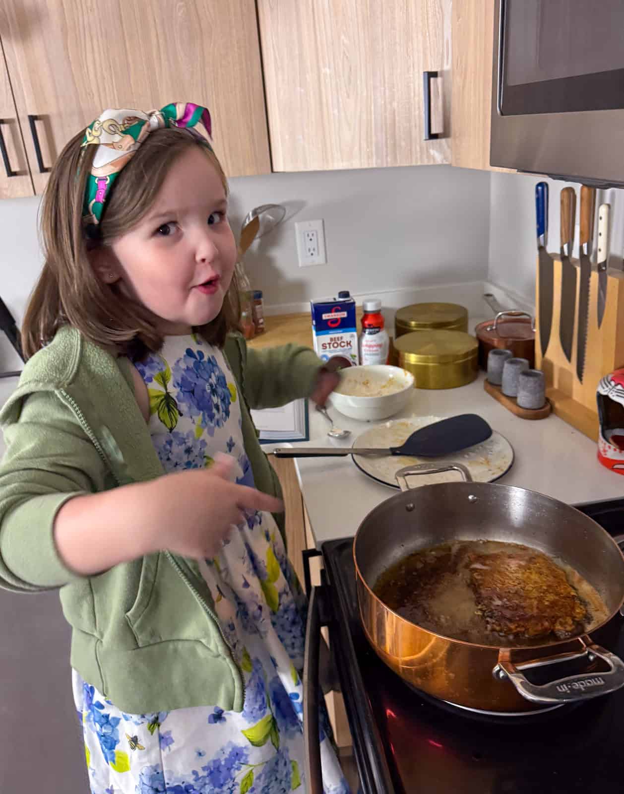 Kat is frying the cube steaks in hot oil and pointing at the food