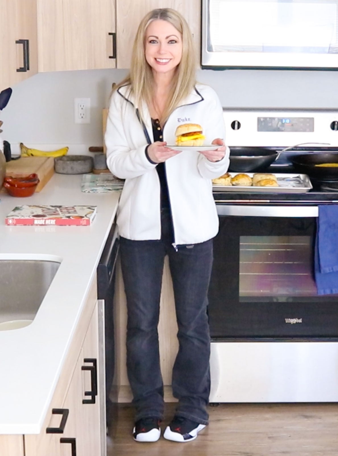 Kristin is holding a Chinatown Breakfast Sando beside Made Here cookbook
