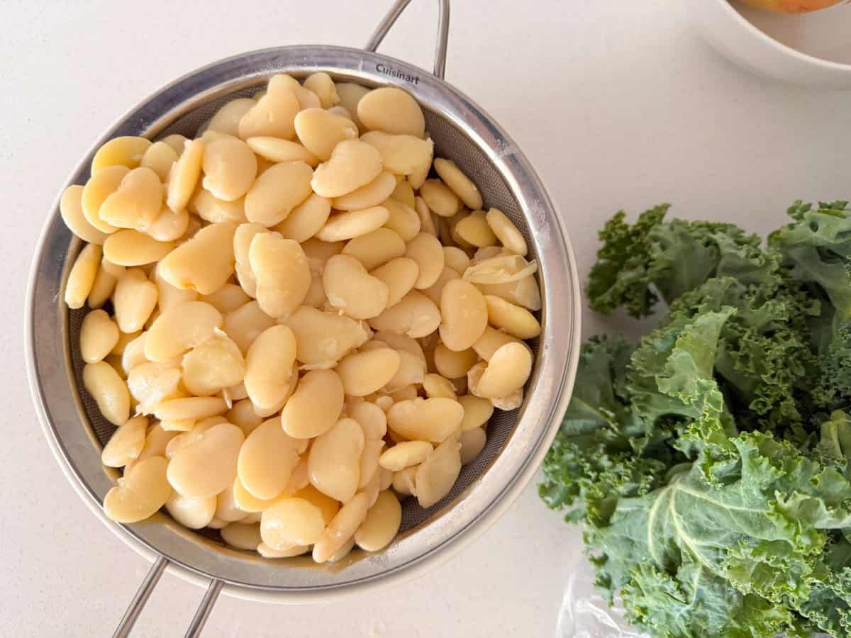 large white lima beans in a fine mesh strainer over a bowl