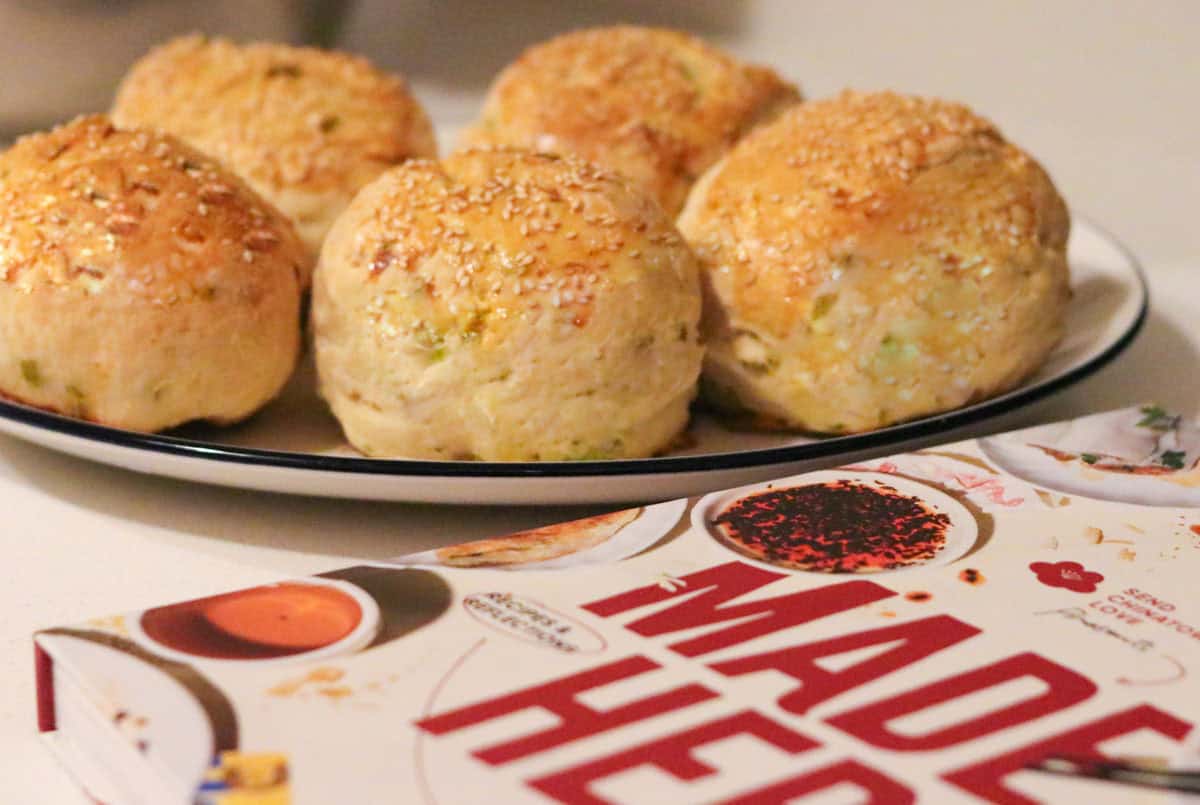 sesame scallion milk buns on a plate beside Made Here cookbook