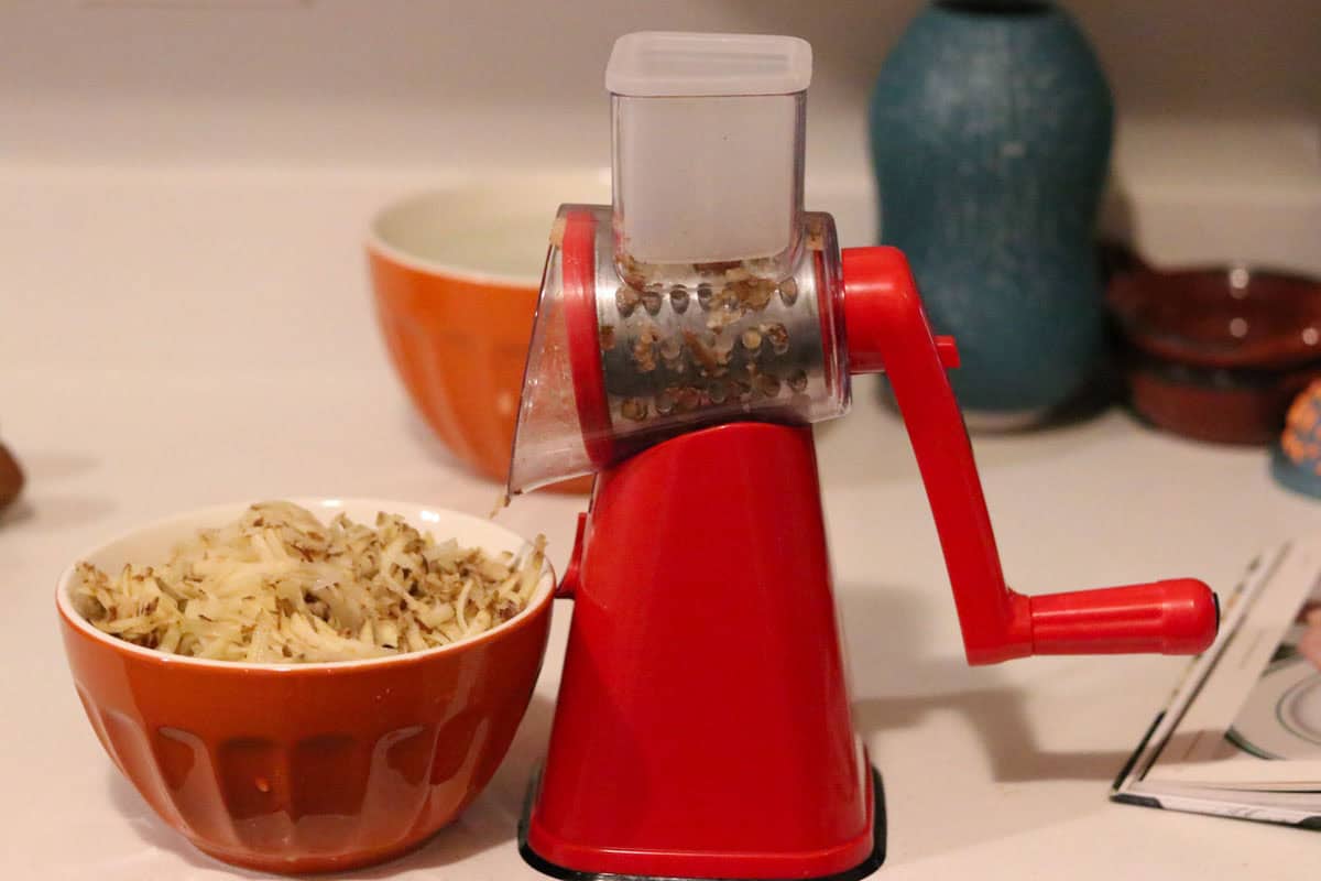 a bowl with shredded potaotes beside a NutriSlicer