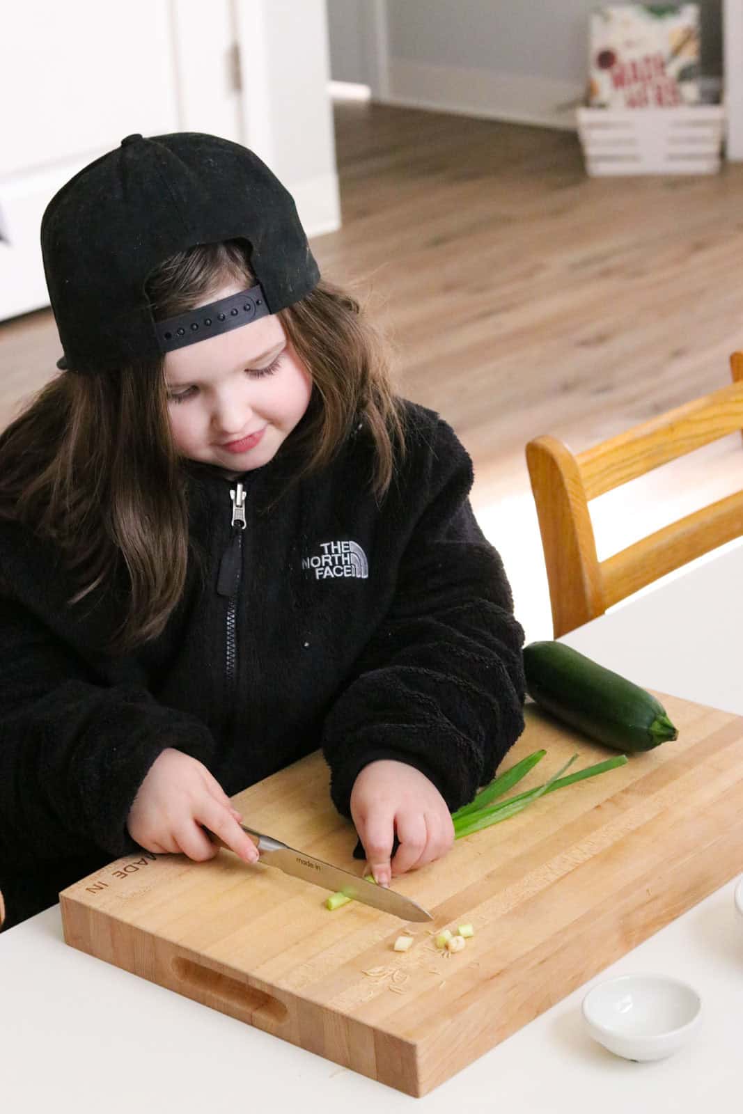Katalina is dicing green onions with a utility knife