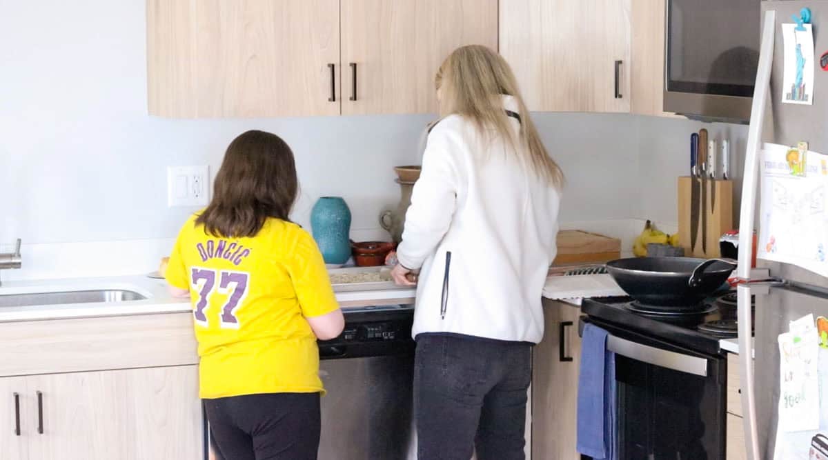 Kristin is slicing the potatoes with a knife