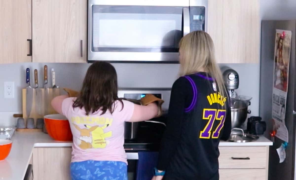 Kaia is draining potatoes over a stock pot