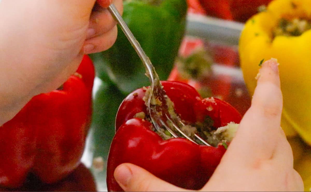 Kaia is stuffing bell peppers using a fork