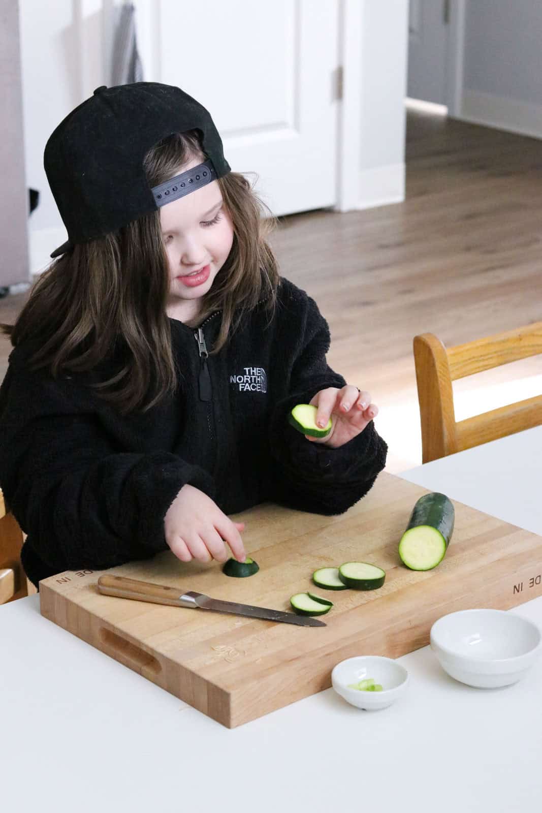 Katalina is slicing zucchini with a utility knife