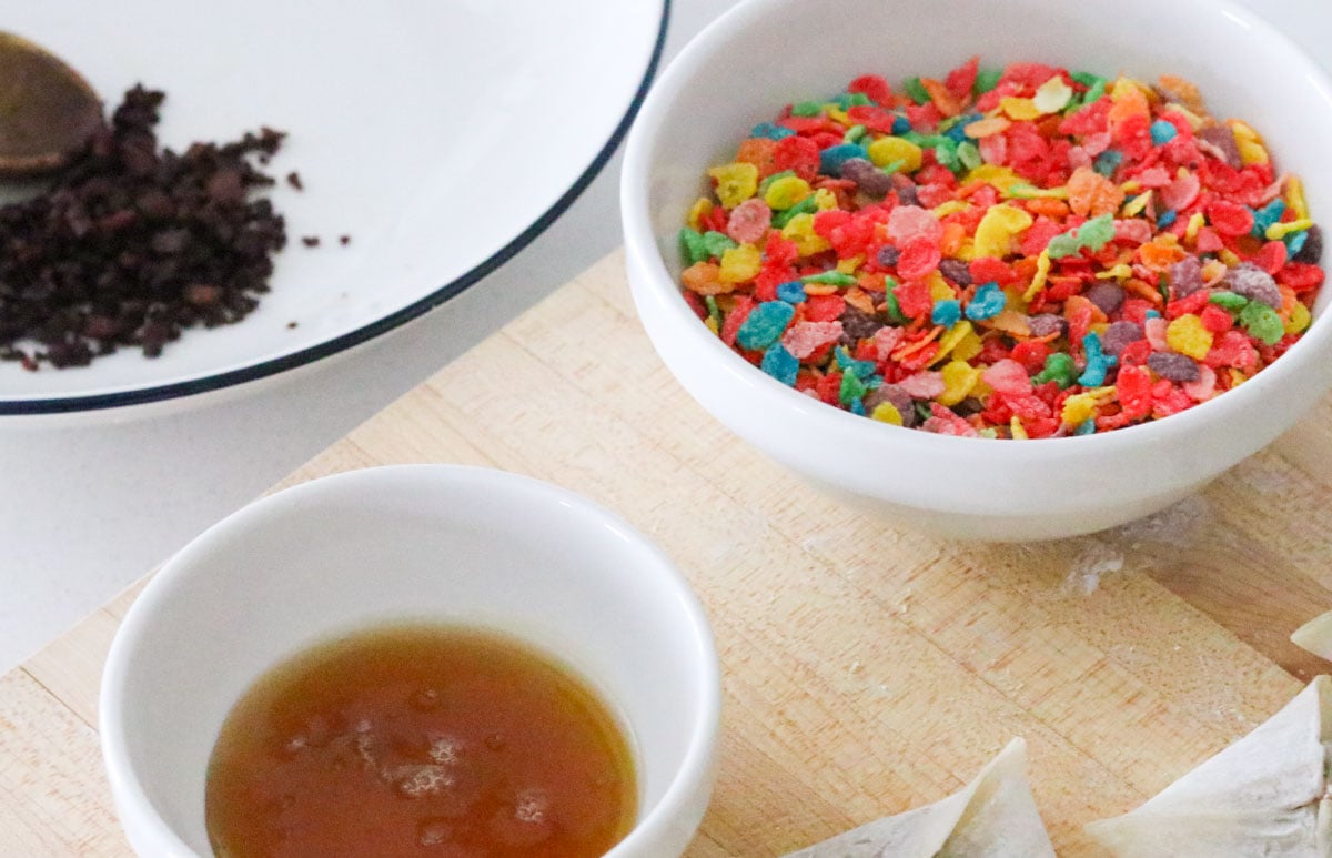 cooked hot dog bits, Fruity Pebbles, and honey in clean bowls