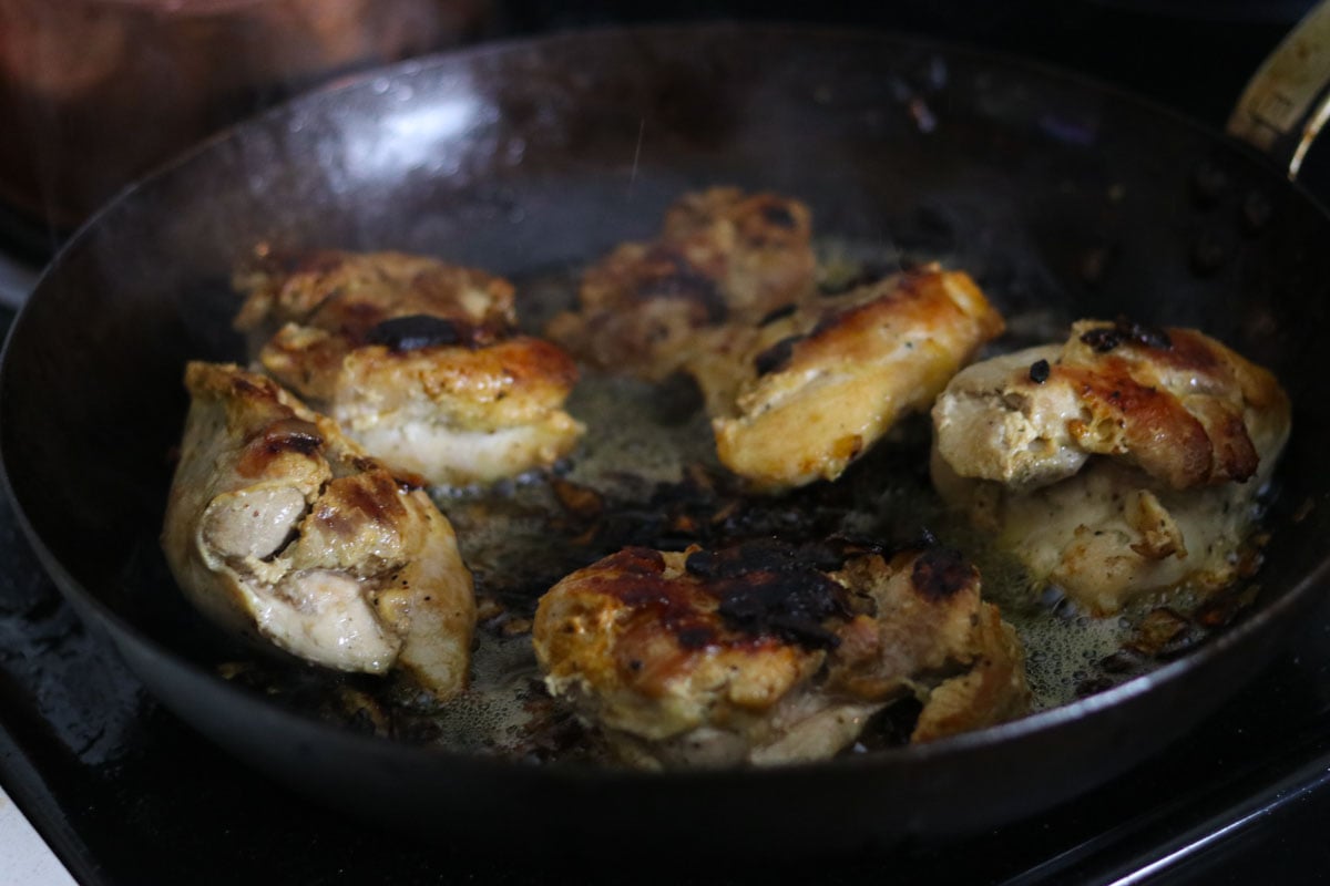 cooked chicken thighs in a carbon steel pan