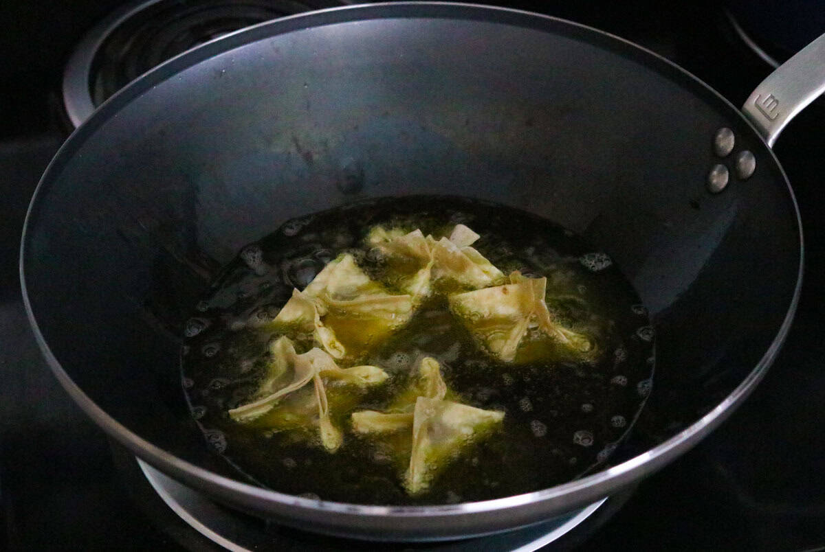 cake rangoons frying in a wok