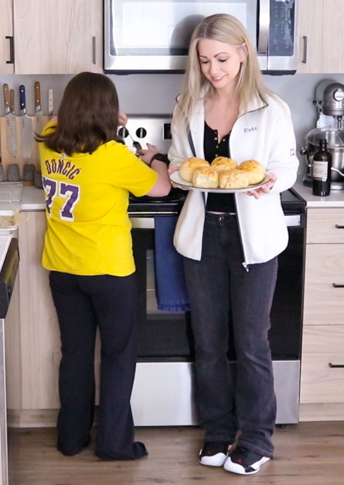 Kaia is at the stove and Kristin is holding sesame scallion milk buns