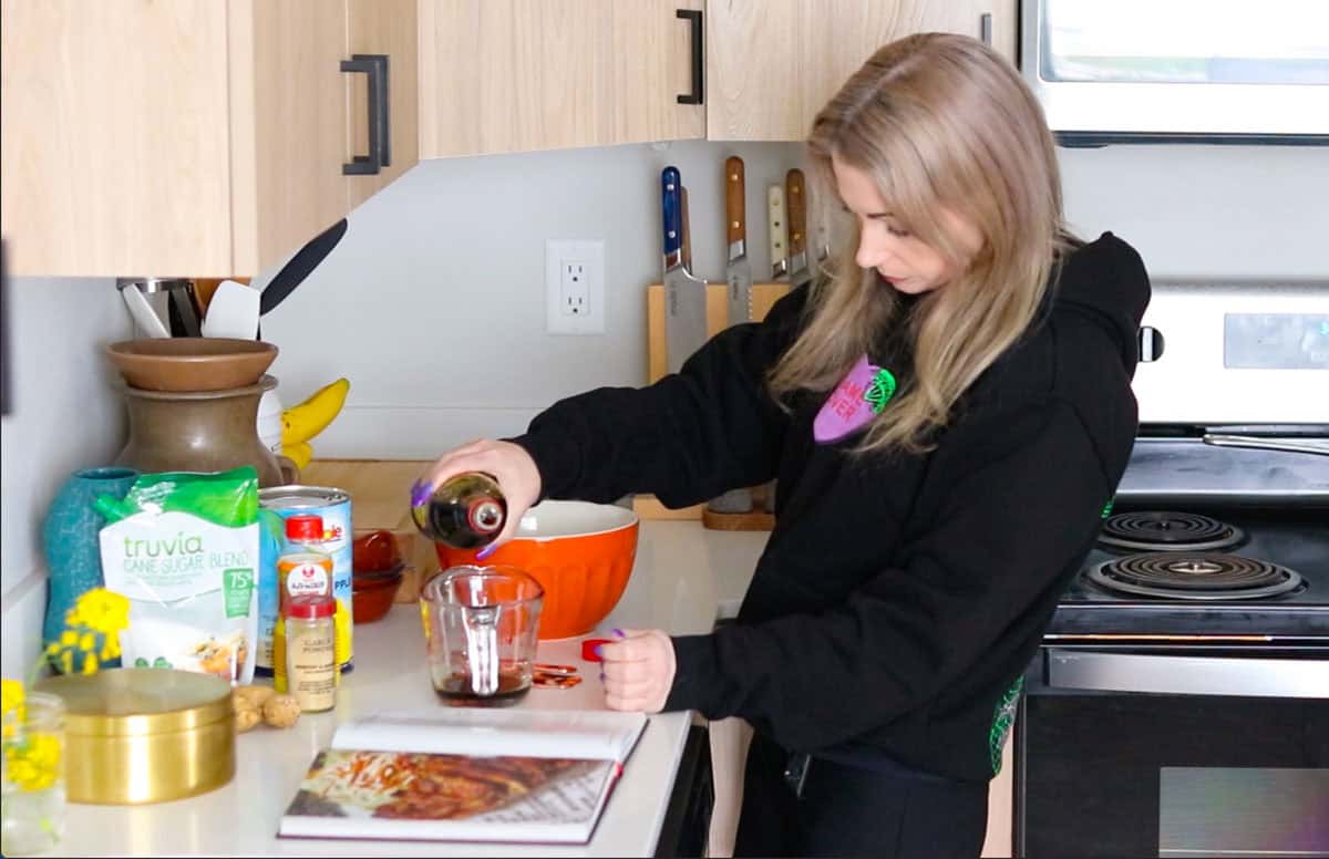 Kristin is pouring soy sauce into a measuring cup