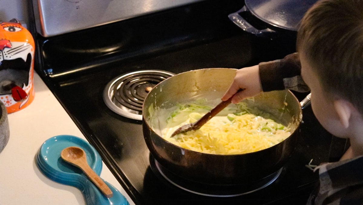 John is stirring cheese sauce