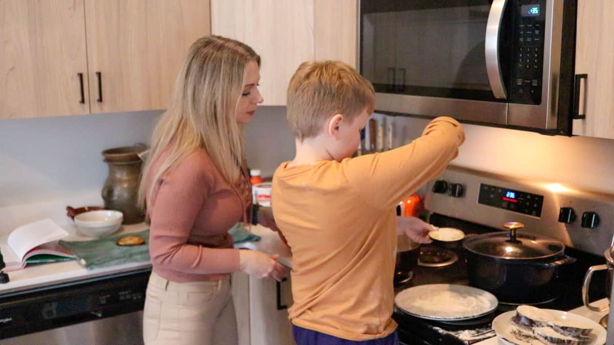 Noah is sprinkling flour on eggplant slices